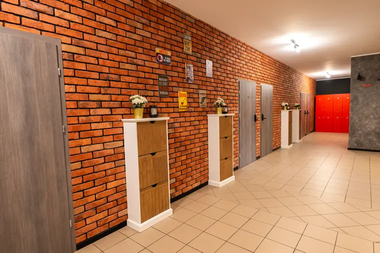 Korytarz z ceglaną ścianą i komodami