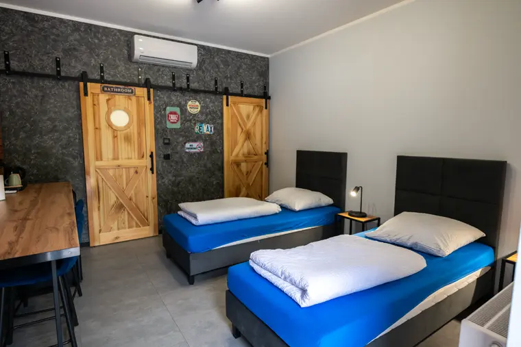 Pokój z cegłą i niebieskimi łóżkami